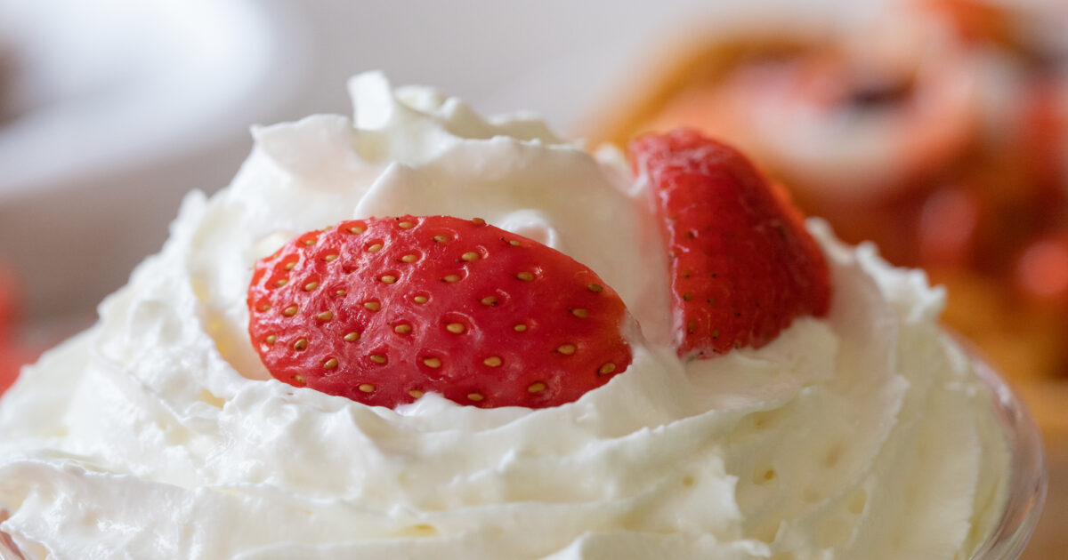 Closeup selective focus shot of whipped cream with fresh strawberries