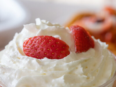 Closeup selective focus shot of whipped cream with fresh strawberries